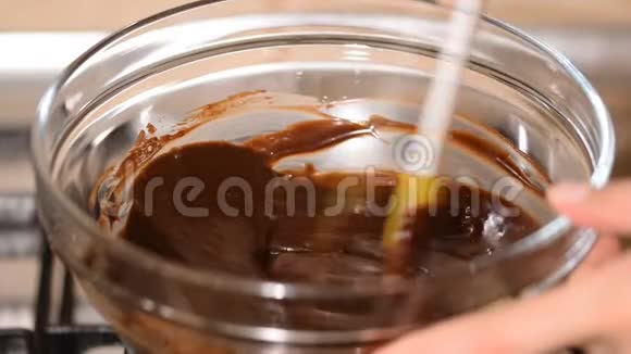 在家里的水浴中融化巧克力的过程的俯视图视频的预览图
