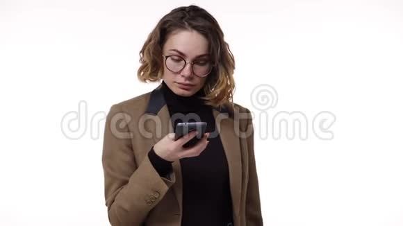一位严肃时尚的年轻女性在与白人隔绝的手机通话时会收到好消息视频的预览图