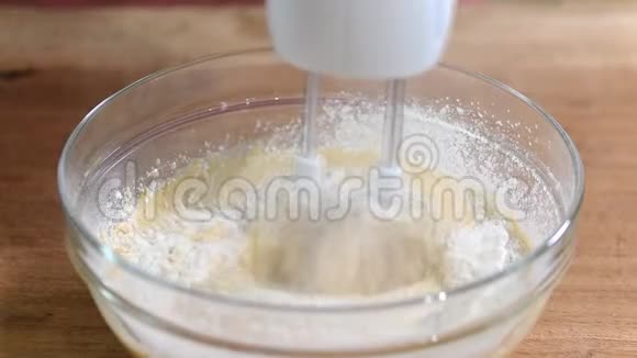 将面粉加入碗中与电动搅拌器混合视频的预览图