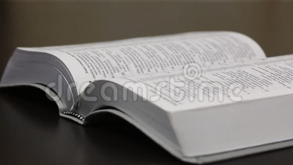 桌子上放着一本公开的圣经相机焦点从一个枢轴转移到另一个枢轴特写镜头视频的预览图