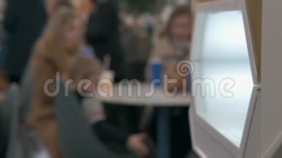 在快餐区的一群人中女人在手上喷洒抗菌剂视频的预览图