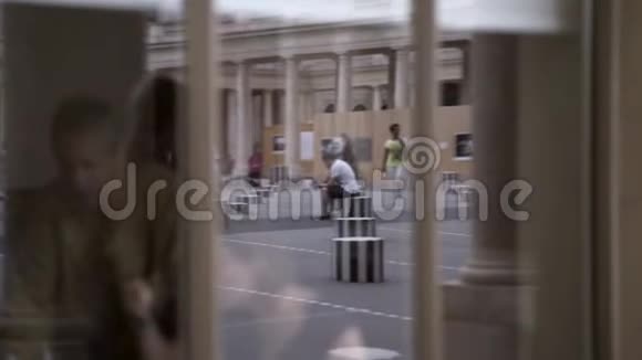 一个穿着黑色衣服的年轻女子在城市街道上行走的倒影行动一个时髦的女孩在视频的预览图