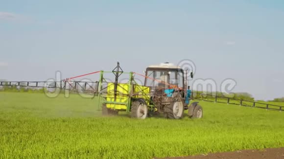 农用拖拉机在日落时用喷雾器除草剂和杀虫剂在田间喷洒农用机械喷洒杀虫剂视频的预览图