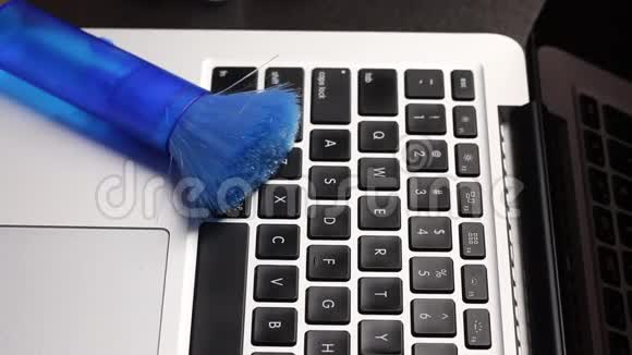 一个戴橡胶手套的人正在清洗他的笔记本电脑用棉签蘸取清洁剂清洁笔记本电脑键盘保护视频的预览图