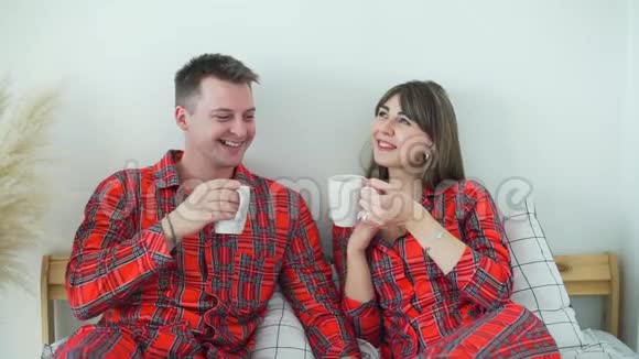 快乐的夫妻在床上喝茶视频的预览图