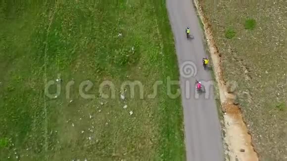 三个骑自行车的人骑自行车鸟瞰公路骑行大自然环绕视频的预览图