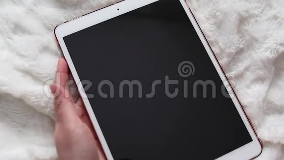 一个人喷洒酒精消毒电子平板上的喷雾清洁细菌病毒和细菌的屏幕视频的预览图