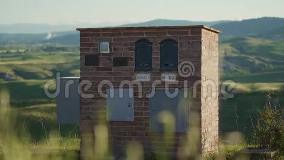 绿色山丘背景下两个家庭的带信箱的砖楼视频的预览图