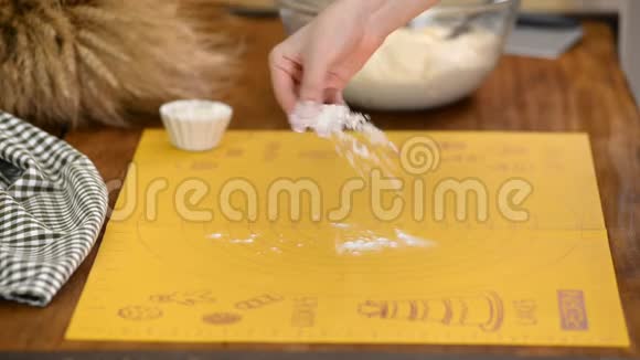 女面包师用面粉将面团揉在工作表面视频的预览图