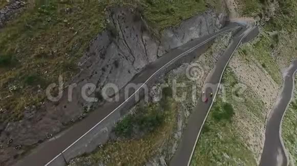自行车骑在蛇形公路上的公路山地自行车骑自行车作为夏季运动视频的预览图