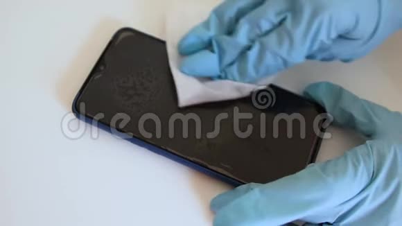 戴医用乳胶手套的人用抗冠状病毒抗菌擦拭智能手机屏幕视频的预览图