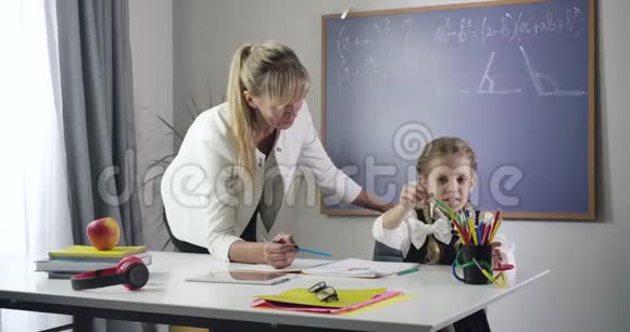 小白种人女孩选择彩色铅笔在练习本中画画在家做家教的孩子视频的预览图