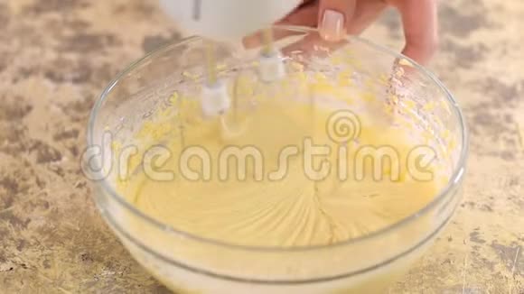 一位混合面团电动搅拌器的女厨师的俯视图用电动搅拌机搅拌面团视频的预览图
