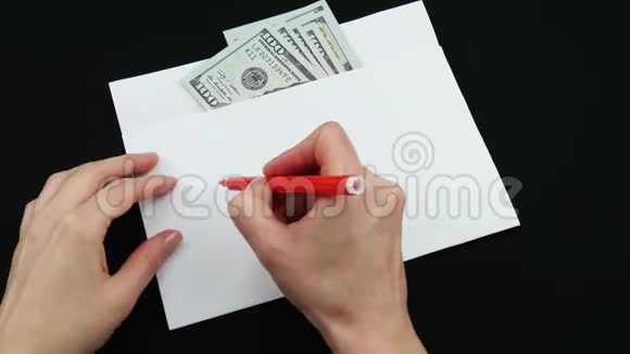 白色信封里的钱在黑色的背景上一个无名的人的手把信用的单词写在视频的预览图
