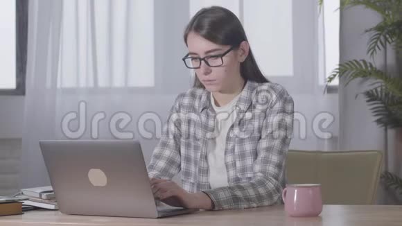 年轻女性白人自由职业者睡着的肖像坐在桌子上拿着笔记本电脑精疲力竭的年轻女孩视频的预览图