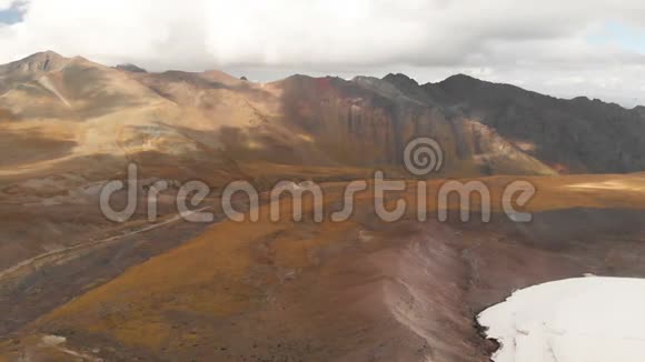 以厄尔布鲁斯山和一个大冰川为背景的火山岩俯瞰图视频的预览图