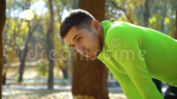 秋季公园慢跑后帅哥运动员呼吸急促视频的预览图