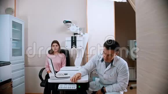 眼科医生年轻妇女在眼科诊所探视儿童医生医生和一个年轻的女人说话视频的预览图