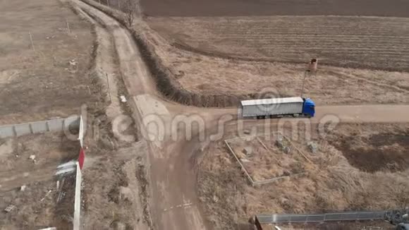 一辆大型卡车和一辆拖车沿着土路行驶在附近寻找掉头的地方视频的预览图