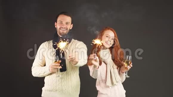 在黑色背景下带着香槟杯和火花的幸福夫妇慢镜头视频的预览图