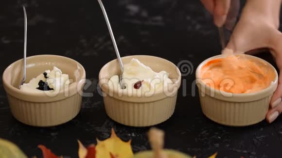 女性的手把奶油和凝胶状的食用色素混合在一个小碗里视频的预览图