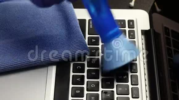 一个戴橡胶手套的人正在清洗他的笔记本电脑一种特殊的刷子可以清除键盘和笔记本电脑屏幕上的灰尘保护视频的预览图