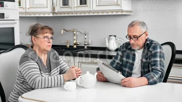 自信的老人喝早茶看报纸和妻子一起吃早餐视频的预览图
