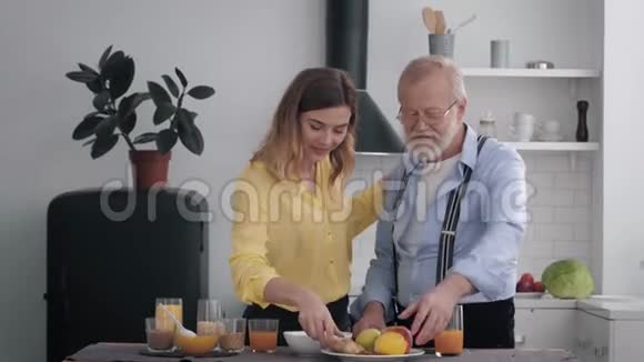 快乐的家庭快乐的爷爷和他微笑的孙女在厨房里玩得开心用健康的食物做早餐视频的预览图