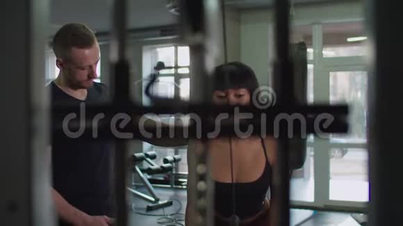 女性在健身房做三头肌绳推运动视频的预览图