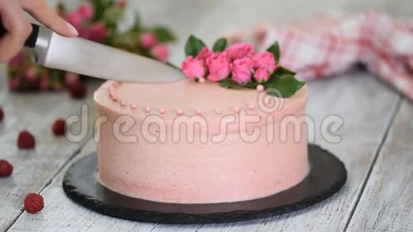 女人切一个用玫瑰装饰的漂亮蛋糕甜食视频的预览图