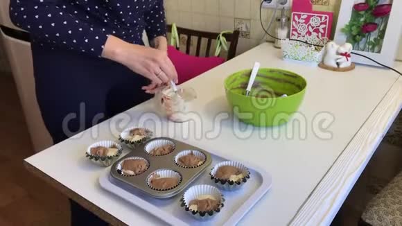 女人把面团和可可放在松饼烤盘里表格里已经有一点轻面团视频的预览图