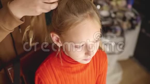 给严肃女孩做发型的女人视频的预览图