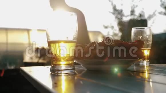 日落时喝杯啤酒降温消暑饮品理念群友及烧烤区背景视频的预览图