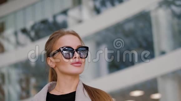 年轻女子外表迷人戴着太阳镜四处张望视频的预览图