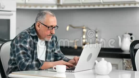 热情成熟的戴眼镜的男性喜欢在笔记本电脑键盘上打字视频的预览图