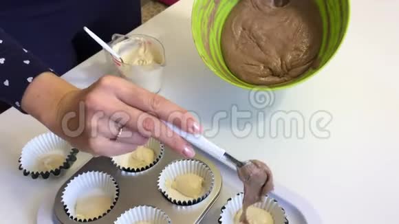 一个女人把有可可的面团放在松饼烤盘里做一个大理石蛋糕从上面看视频的预览图