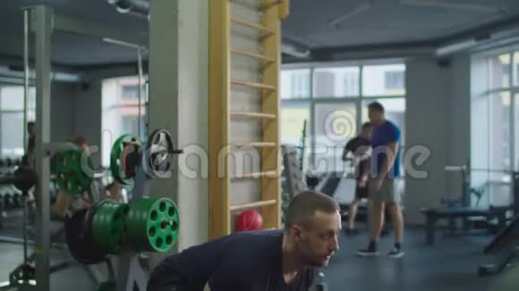 肌肉男在健身房用水壶做运动视频的预览图