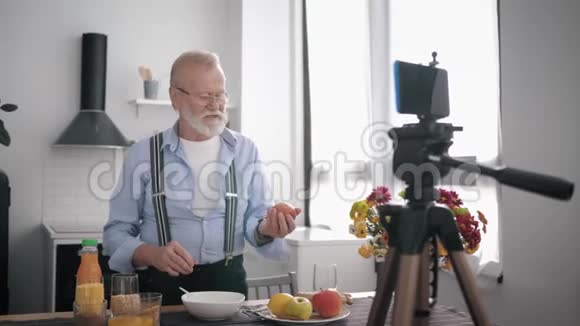 健康食品一位留着胡须和视力眼镜的老人建议适当的营养并展示各种谷类食品视频的预览图
