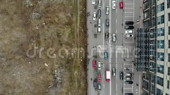 空中无人机的街景与移动的人和汽车现代建筑与荒地的对比上景这就是视频的预览图