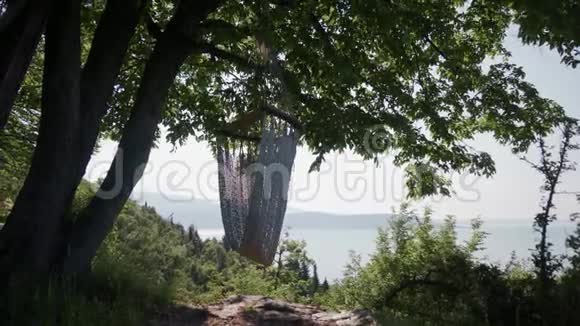 空吊床挂在树上提供舒适的休闲场所可欣赏加德纳湖风景视频的预览图