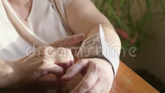 用手指按压数字血压计对自测血压进行特写妇女健康检查视频的预览图