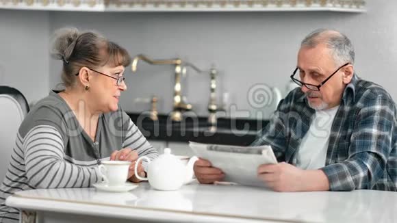 中老年夫妇在早餐时谈论辩论白厨房中档视频的预览图