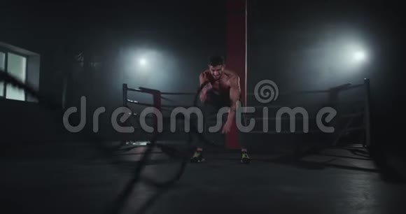 体操课的运动员有一个有魅力的脸用绳子做运动他有一个艰苦的锻炼训练缓慢的动作视频的预览图