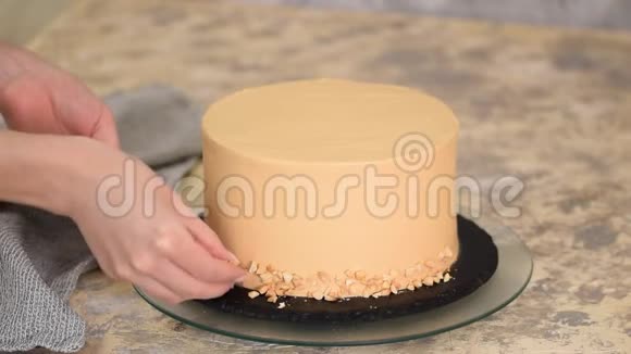 糕点厨师用花生装饰焦糖蛋糕视频的预览图