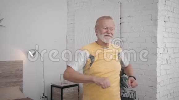 运动与健康生活的微笑的范爷爷在他的房间里进行有益的运动来保持活力视频的预览图