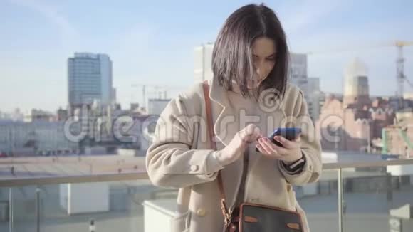 褐发白种人妇女使用智能手机和环顾四周的肖像严肃的女商人在等生意视频的预览图