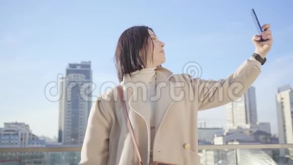 年轻的高加索女人在城里自拍自信的黑发商务女士使用智能手机在城市拍照视频的预览图