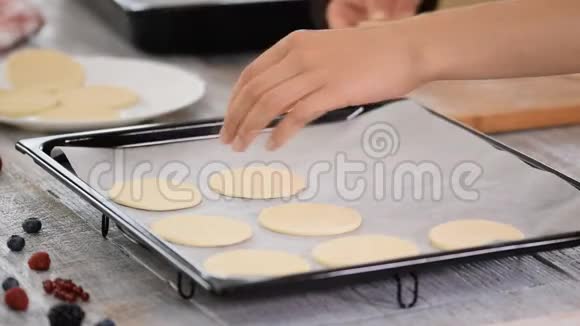 女性手把圆切饼干放在烤盘上视频的预览图