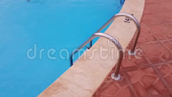 金属梯子到游泳池游泳池里是清澈的蓝色水视频的预览图