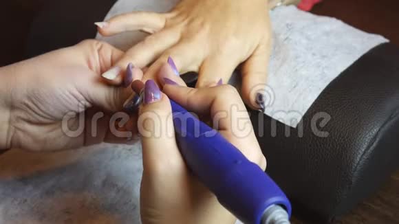女士在美容院使用电指甲锉钻完美的修指甲过程视频的预览图